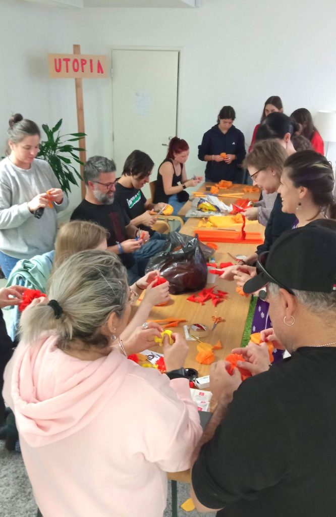 The picture shows a group of people gathering at Globe Art Point office, in Helsinki, creating marigold flowers